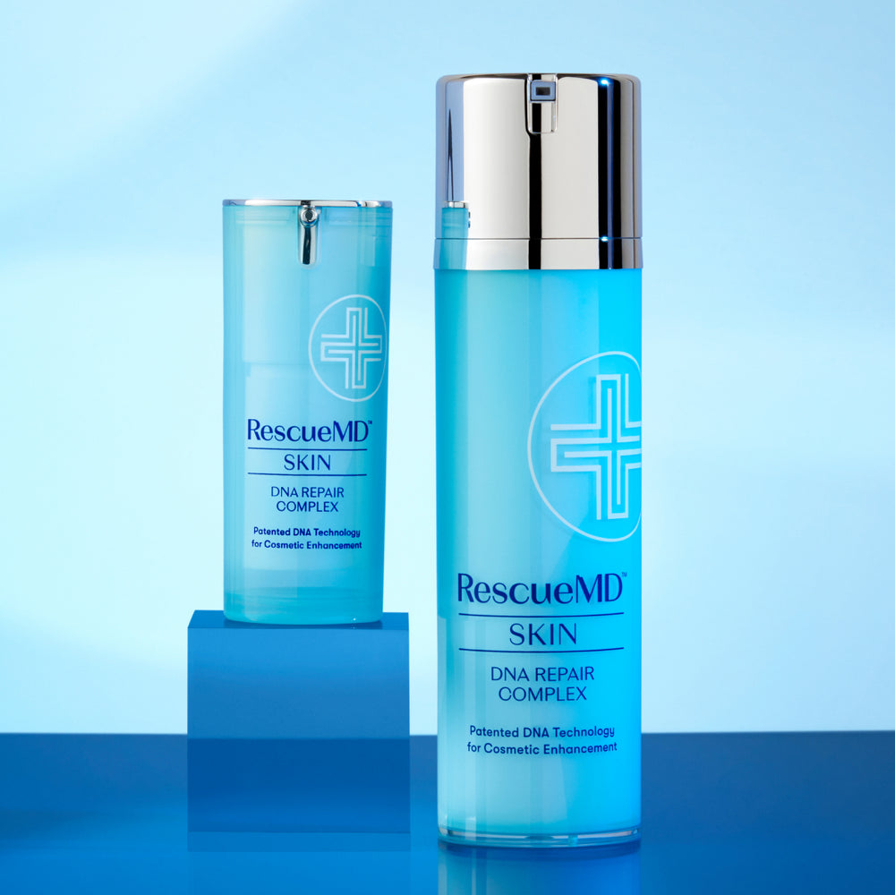 two different sized bottles of RescueMD serum on a blue surface, with the smaller bottle placed on top of a box-like structure