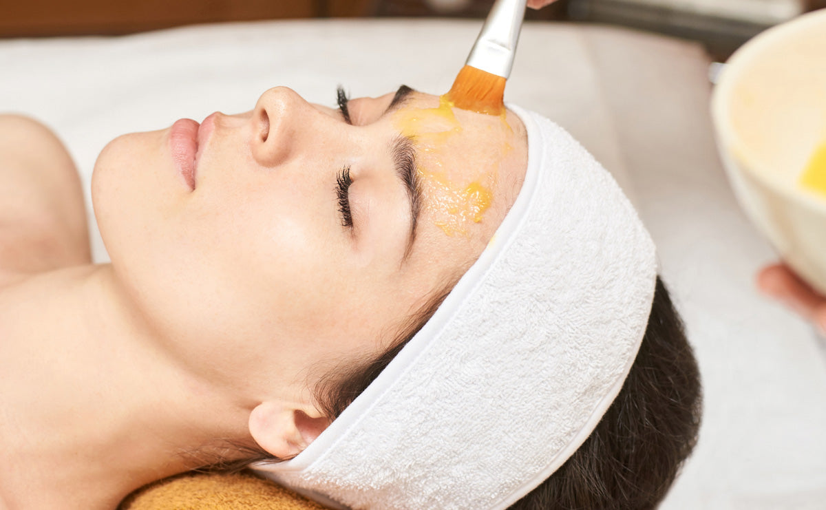 woman receiving a chemical peel application on treatment bed