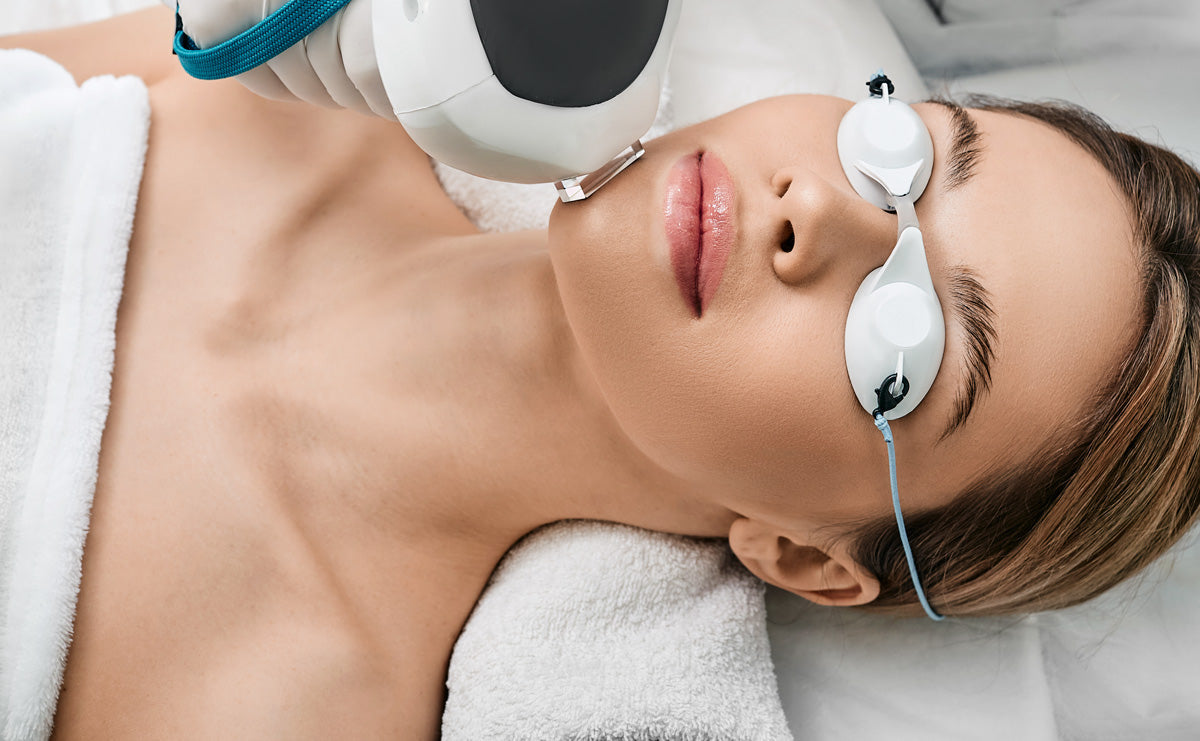woman lying on a treatment bed receiving Intense pulsed light (IPL) therapy