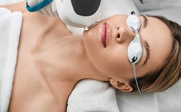 woman lying on a treatment bed receiving Intense pulsed light (IPL) therapy