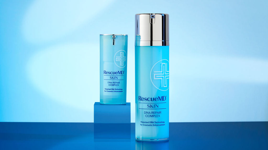 two different sized bottles of RescueMD serum on a blue surface, with the smaller bottle placed on top of a box-like structure