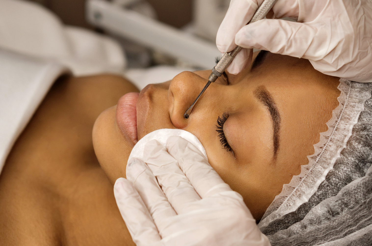 woman with closed eyes receiving a skin treatment while lying on a treatment bed