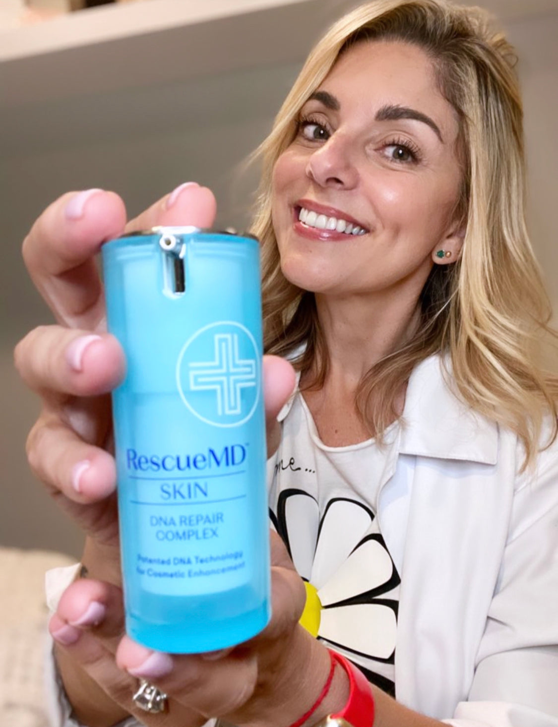 female esthetician happily showing RescueMD product bottle package, recommending to patients