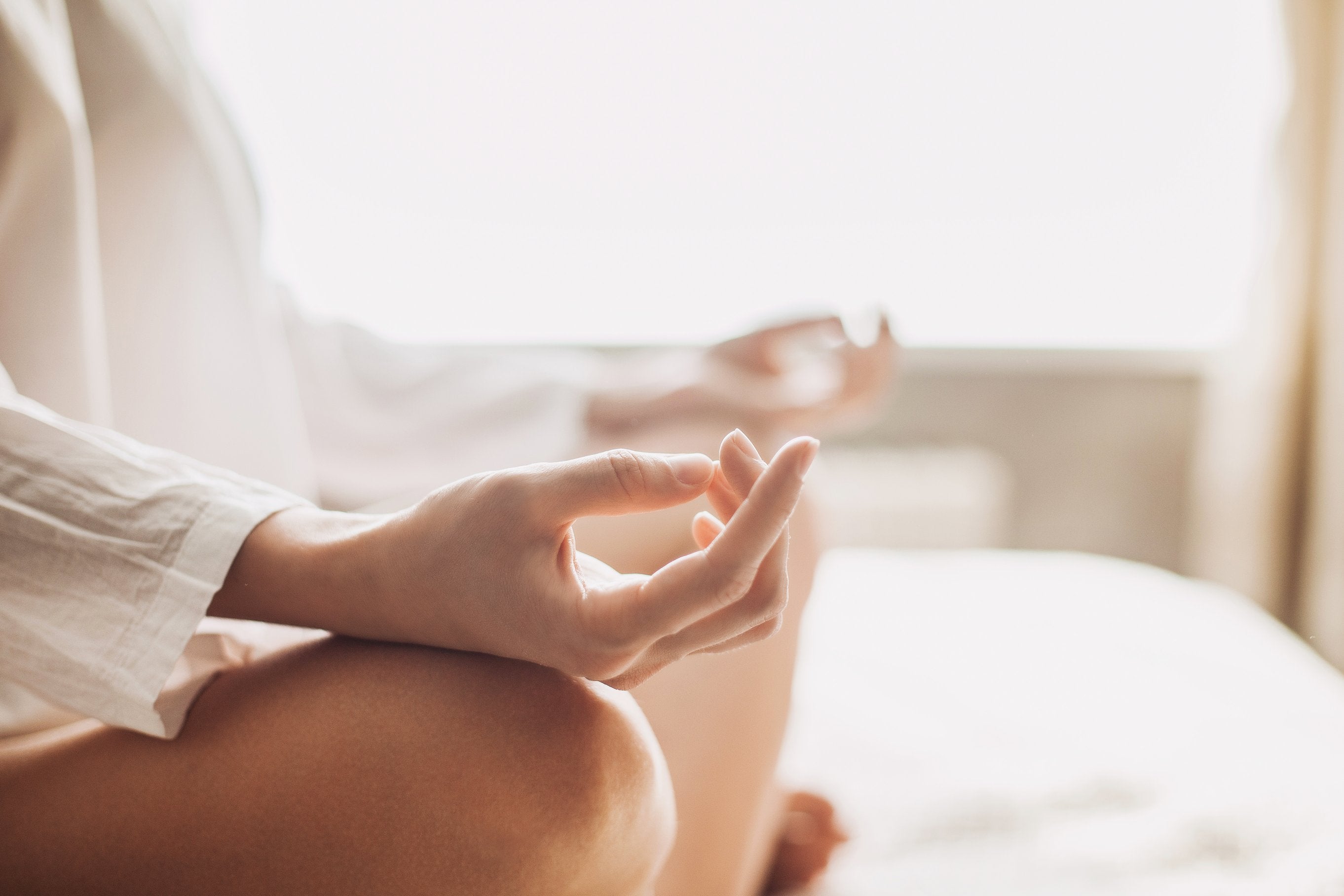 a close-up shot of a woman in a sitting position, focused while performing yoga